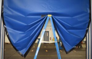 ladder holding up a flexible bottom high performance door