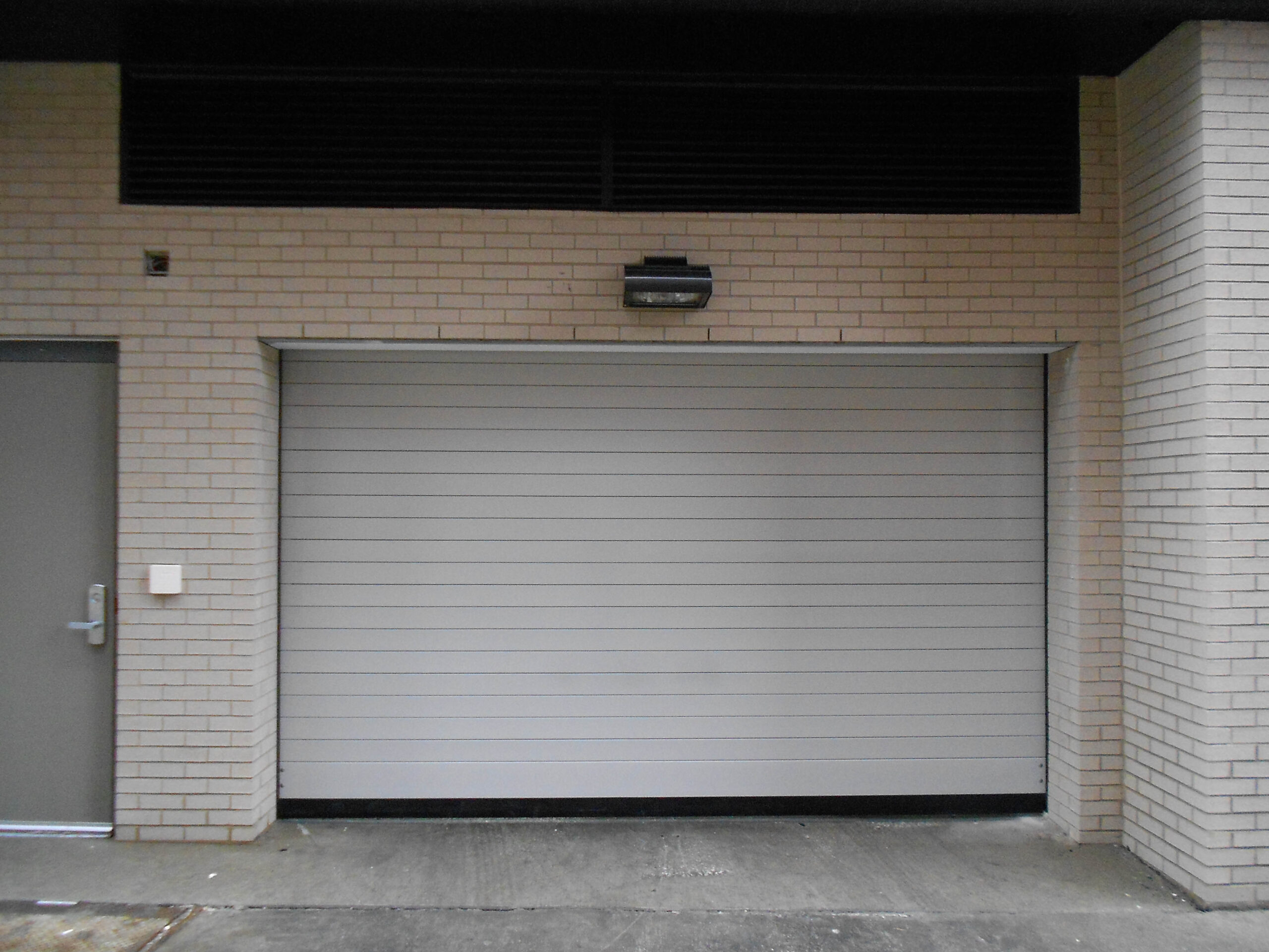 White Brick Parking Facility Building with Closed Garage Door