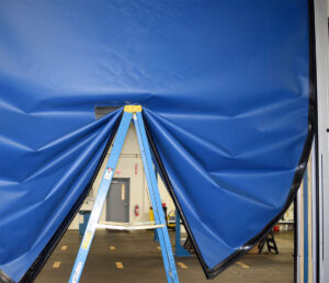ladder holding up FlexTec fabric warehouse door